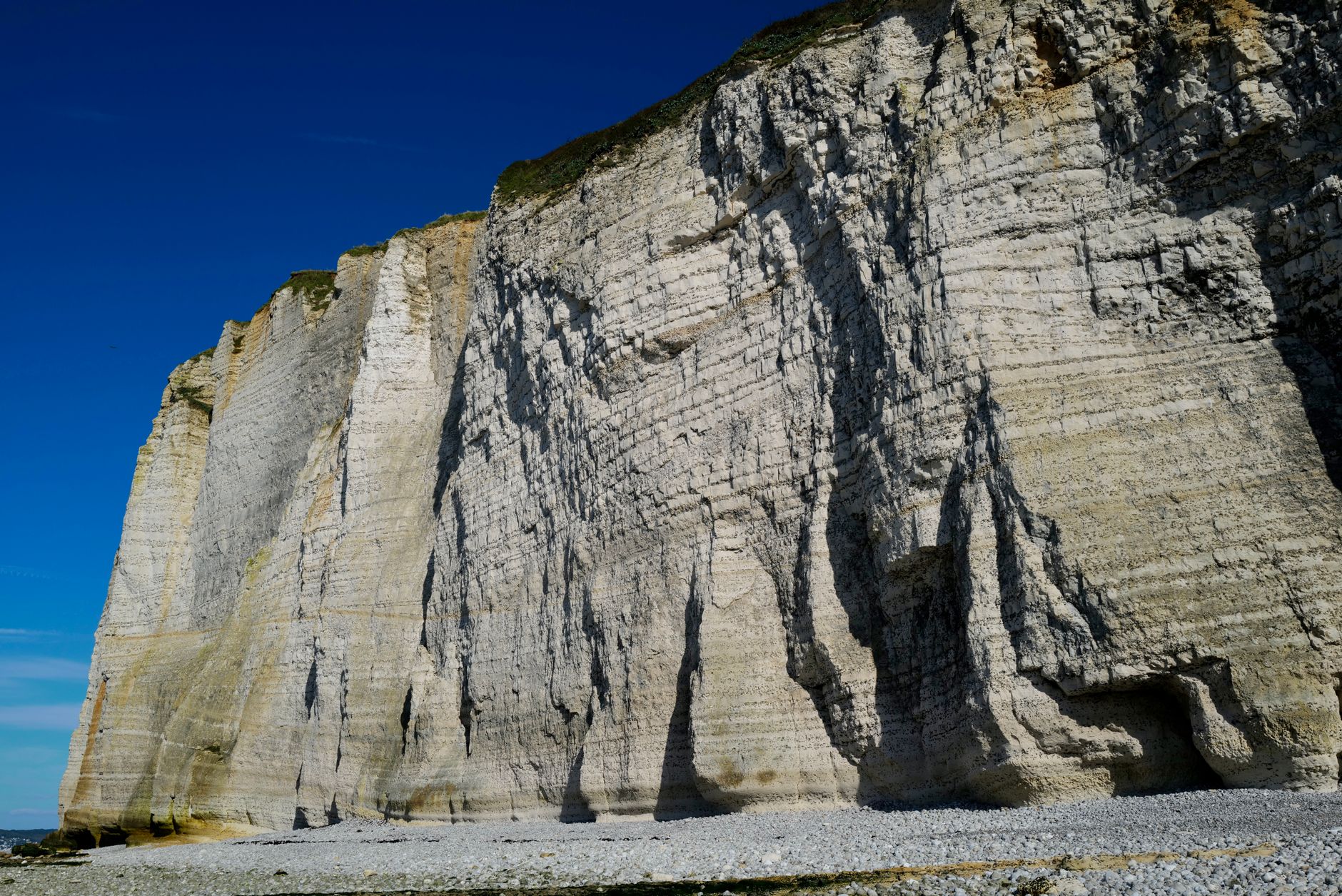 Stunning limestone cliffs with rugged texture against clear blue sky, showcasing natural beauty and rocky formations.